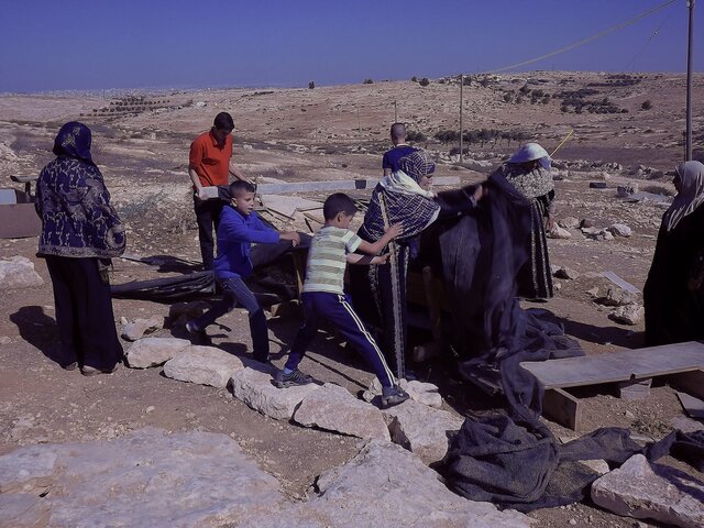 Susiya. Palestinians dismantling the illegal Israeli tent.